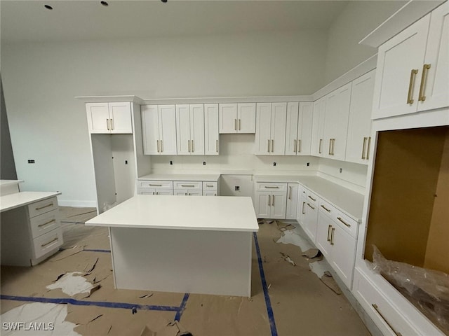 kitchen featuring a high ceiling, white cabinetry, and a center island