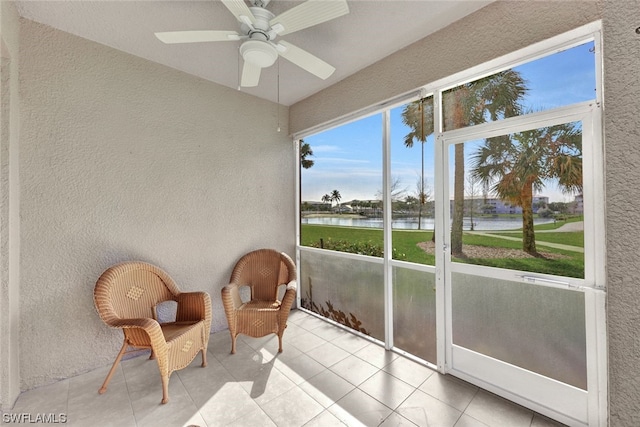 sunroom with a water view and ceiling fan