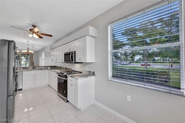 kitchen with stainless steel appliances, light tile floors, white cabinetry, and a wealth of natural light