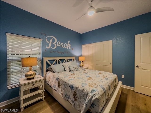 bedroom featuring ceiling fan, a closet, and dark wood-type flooring