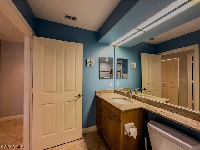 bathroom with vanity, tile floors, and toilet