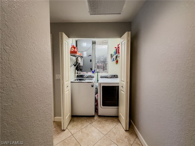 interior space with light tile flooring and washing machine and clothes dryer