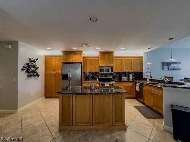 kitchen featuring kitchen peninsula, pendant lighting, light tile floors, appliances with stainless steel finishes, and dark stone countertops