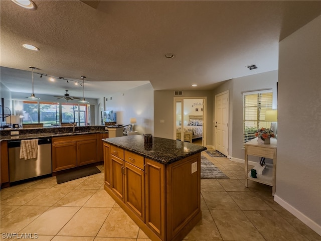 kitchen featuring hanging light fixtures, ceiling fan, light tile flooring, dark stone counters, and dishwasher