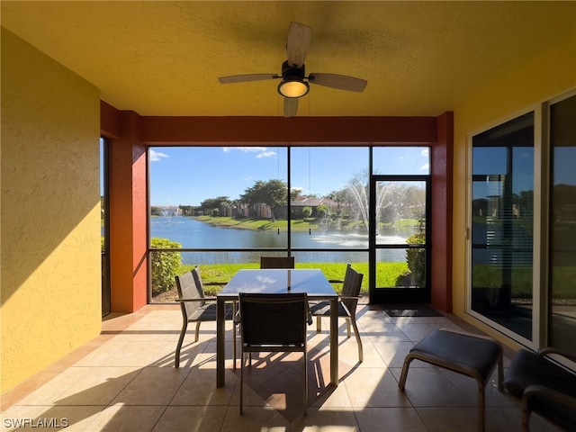 sunroom / solarium with a water view and ceiling fan