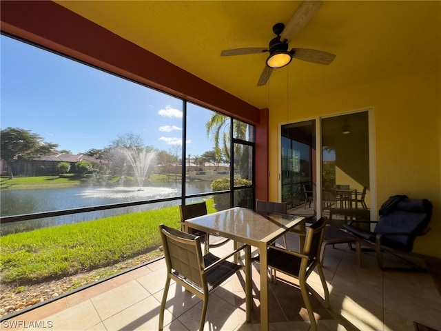 sunroom / solarium with ceiling fan and a water view