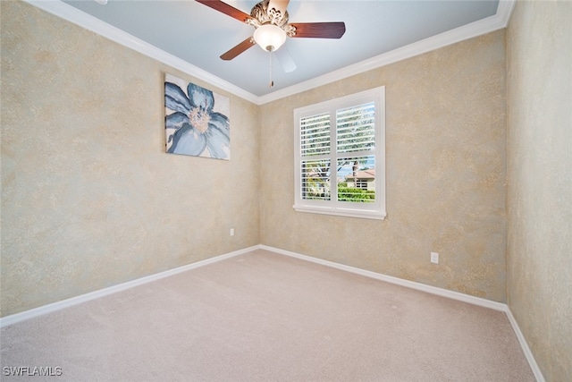 carpeted spare room featuring ceiling fan and ornamental molding