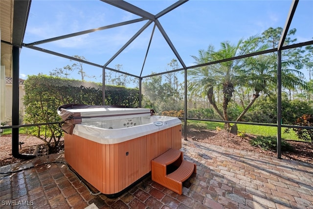 view of patio with glass enclosure and a hot tub