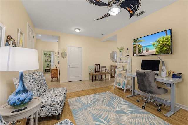 tiled home office featuring ceiling fan