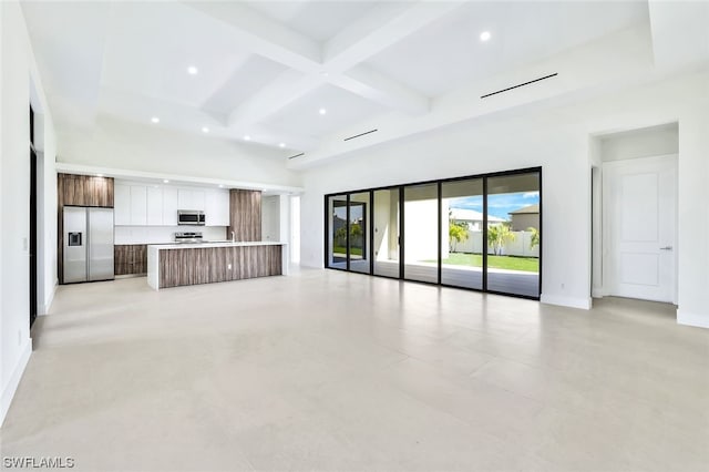 unfurnished living room with coffered ceiling, light tile floors, and beamed ceiling