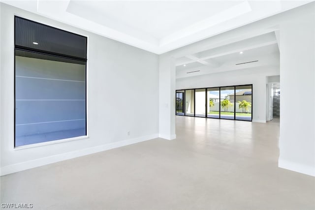 unfurnished room with coffered ceiling and a tray ceiling