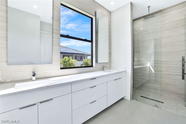 bathroom with tile walls, an enclosed shower, dual bowl vanity, tasteful backsplash, and concrete flooring