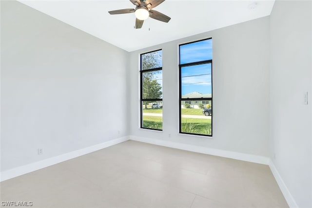 empty room featuring light tile floors and ceiling fan