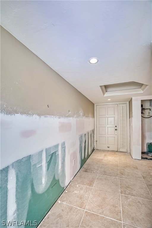 interior space with a tray ceiling and tile floors