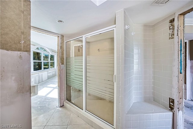 bathroom featuring tile floors and a shower with door