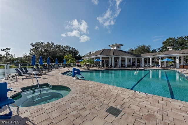 view of swimming pool featuring a community hot tub and a patio area