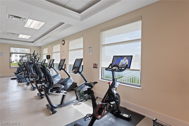 exercise room featuring a raised ceiling