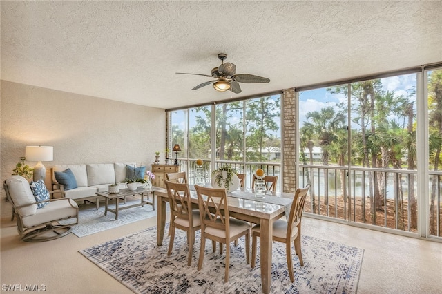 dining area with a textured ceiling, expansive windows, and ceiling fan