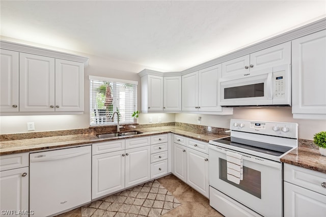 kitchen with white cabinets, white appliances, sink, and dark stone countertops