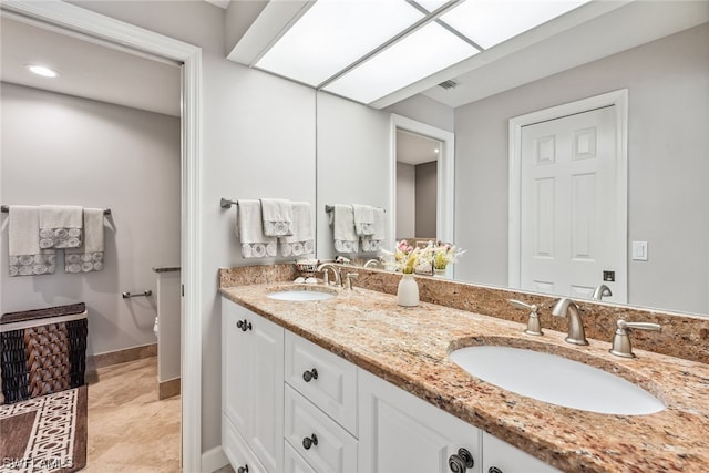 bathroom featuring double sink, large vanity, and tile flooring