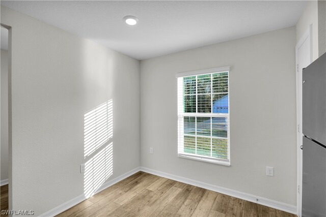 spare room featuring a wealth of natural light and light hardwood / wood-style flooring