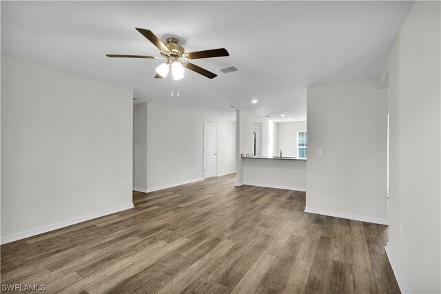 empty room featuring hardwood / wood-style floors, ceiling fan, and sink