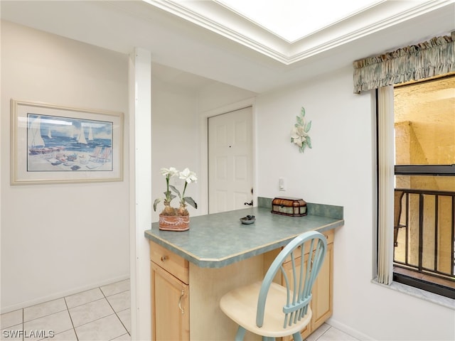 interior space featuring light brown cabinetry, ornamental molding, and light tile patterned flooring