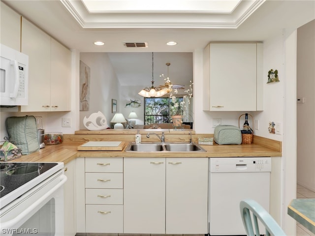 kitchen featuring hanging light fixtures, sink, white cabinets, and white appliances