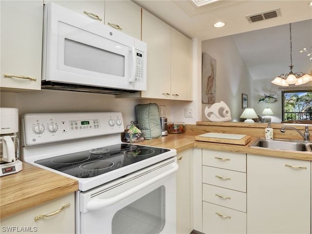 kitchen featuring butcher block counters, sink, hanging light fixtures, white appliances, and an inviting chandelier