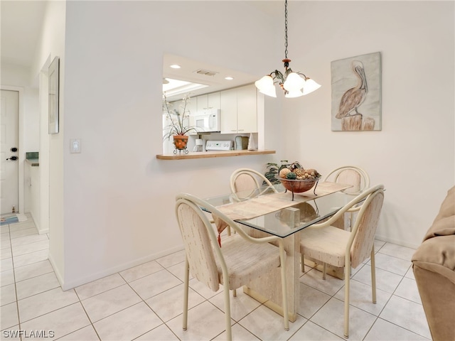 tiled dining area with an inviting chandelier