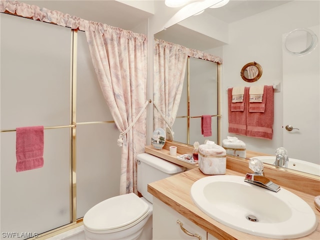 bathroom with walk in shower, vanity, and toilet