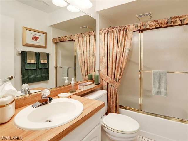 full bathroom with tile patterned floors, vanity, toilet, and combined bath / shower with glass door