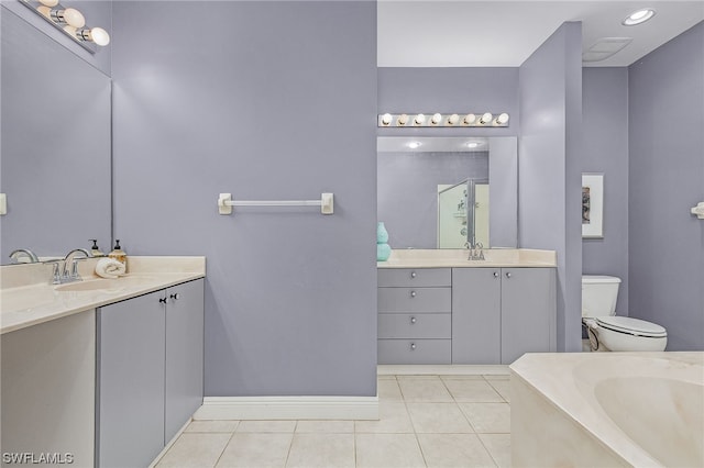 bathroom with toilet, vanity, and tile patterned floors