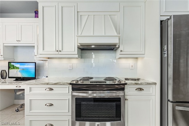 kitchen featuring light stone countertops, light tile patterned floors, premium range hood, white cabinets, and appliances with stainless steel finishes