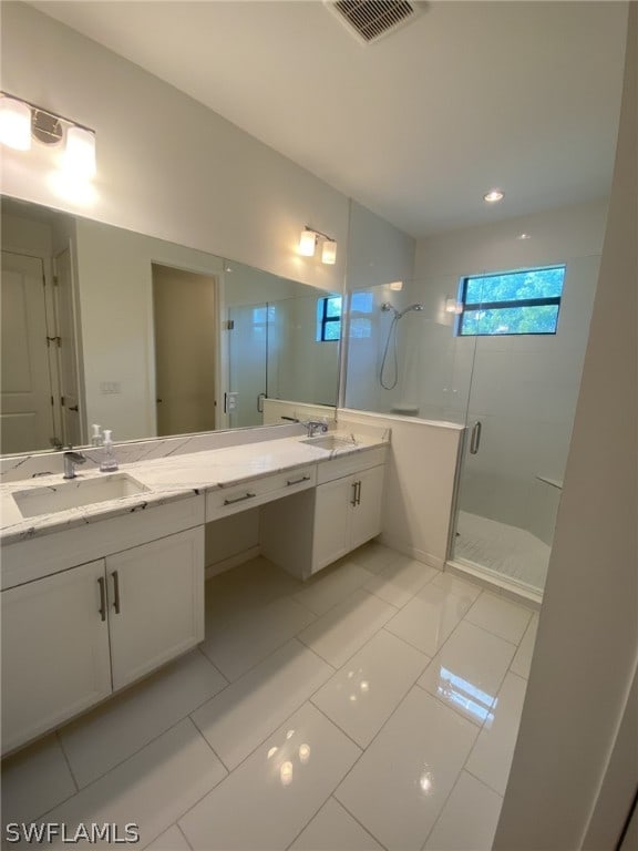 bathroom featuring a shower with door, tile floors, and double sink vanity