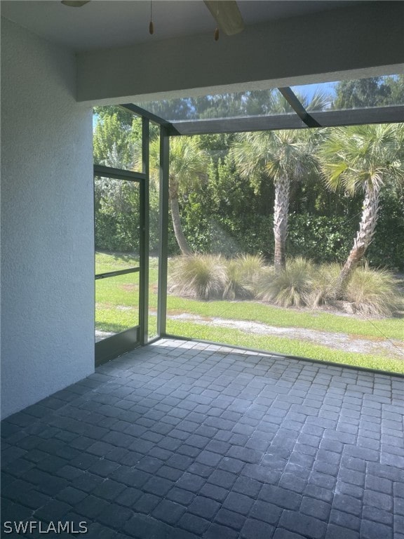 unfurnished sunroom with ceiling fan