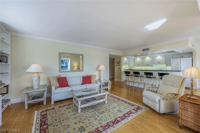 living room with light hardwood / wood-style floors and crown molding