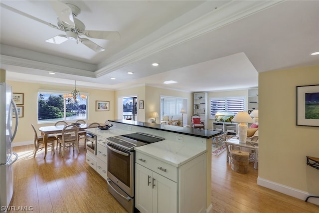 kitchen featuring stainless steel appliances, ceiling fan with notable chandelier, white cabinetry, crown molding, and light wood-type flooring