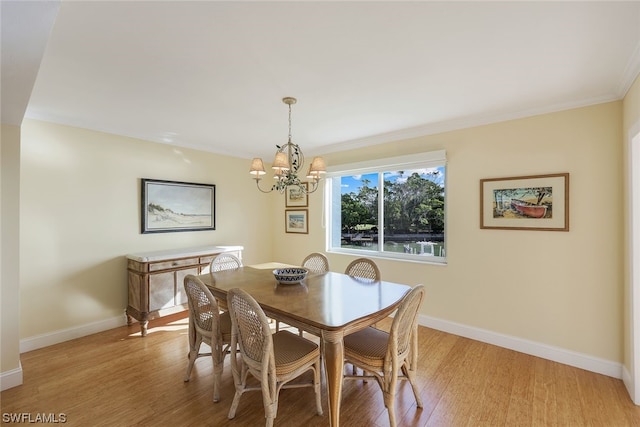 dining space with a chandelier, ornamental molding, and light wood-type flooring