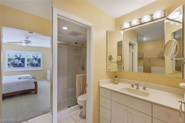 bathroom featuring toilet, a shower with door, ceiling fan, vanity, and tile floors