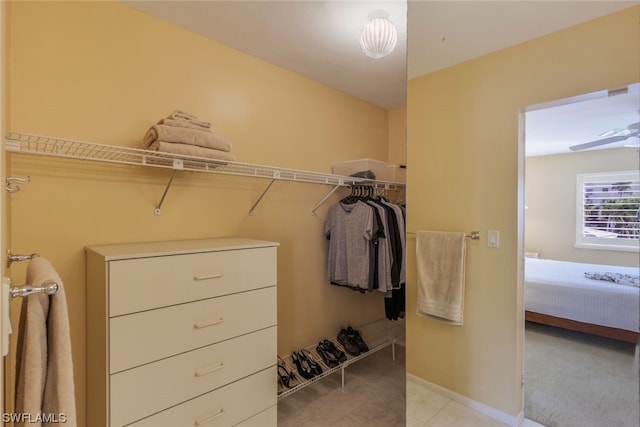 walk in closet featuring light carpet and ceiling fan