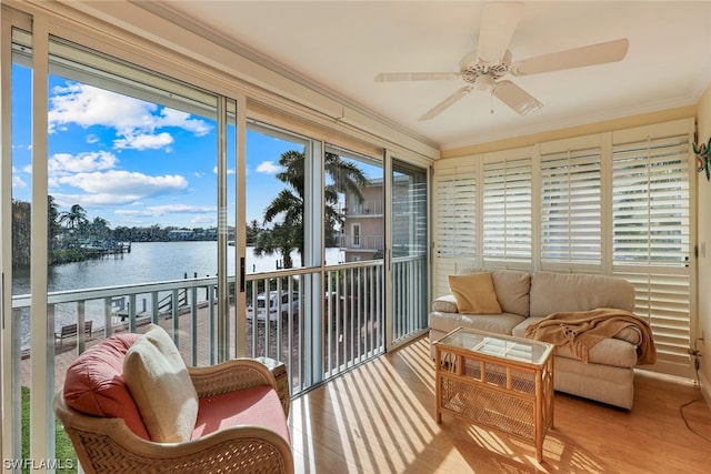 sunroom featuring a water view and ceiling fan