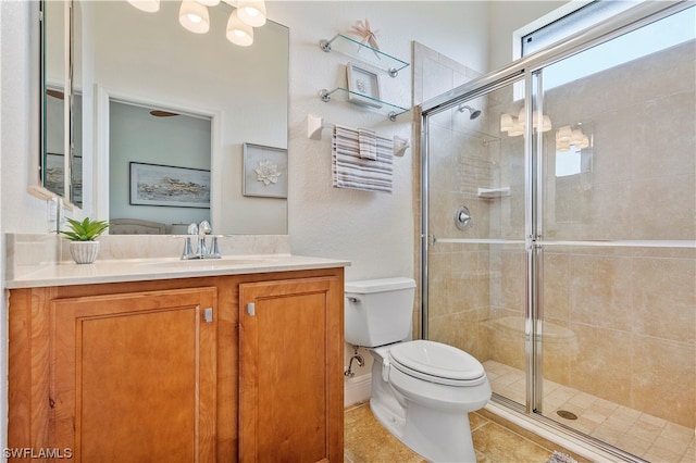 bathroom with vanity, tile floors, a shower with door, and toilet