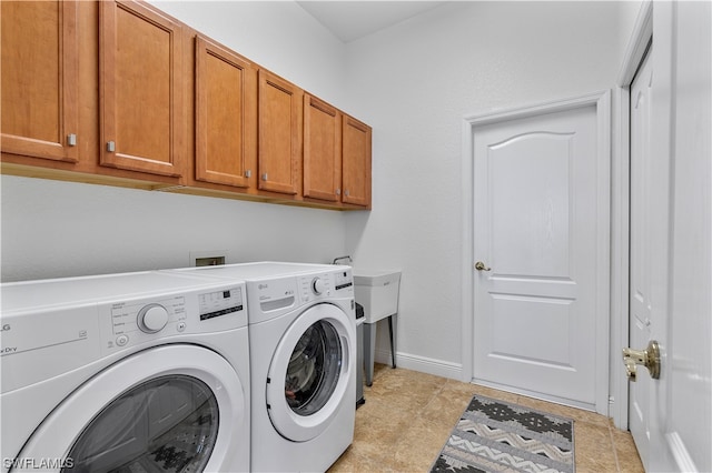 laundry room featuring washing machine and clothes dryer, cabinets, sink, and light tile floors