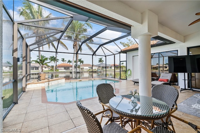 view of swimming pool with ceiling fan, glass enclosure, and a patio