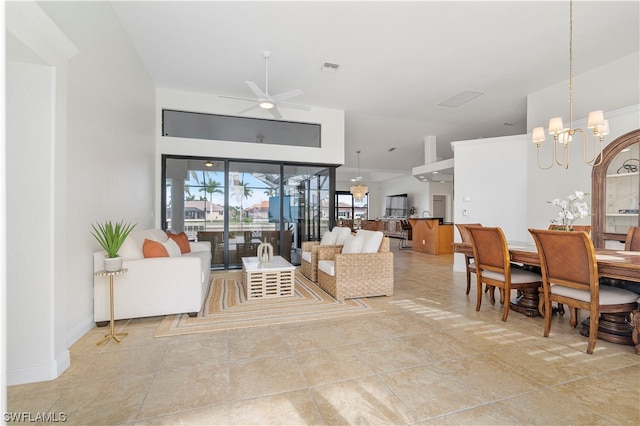 tiled living room featuring ceiling fan with notable chandelier