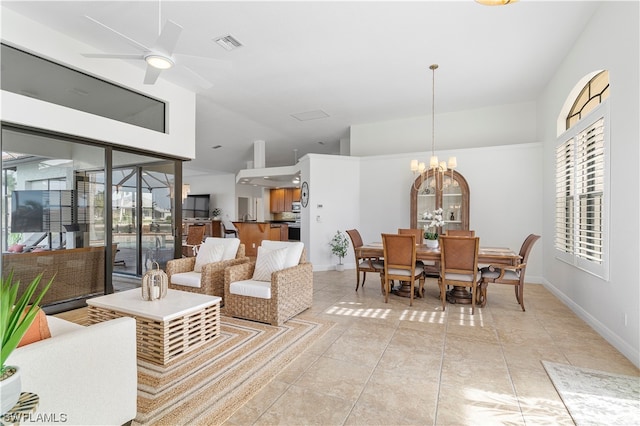 interior space with light tile flooring, ceiling fan with notable chandelier, and a high ceiling