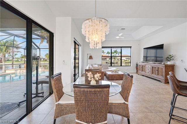 tiled dining room with a raised ceiling and an inviting chandelier