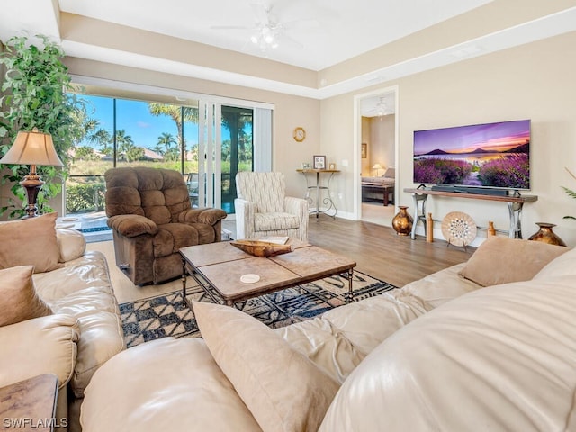 living room featuring hardwood / wood-style floors and ceiling fan