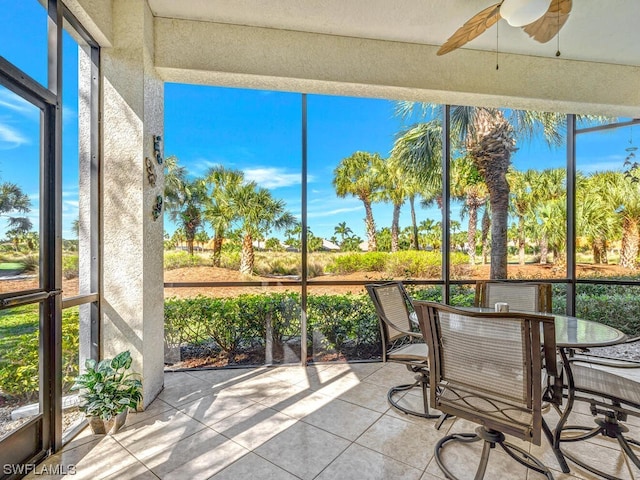 unfurnished sunroom with ceiling fan